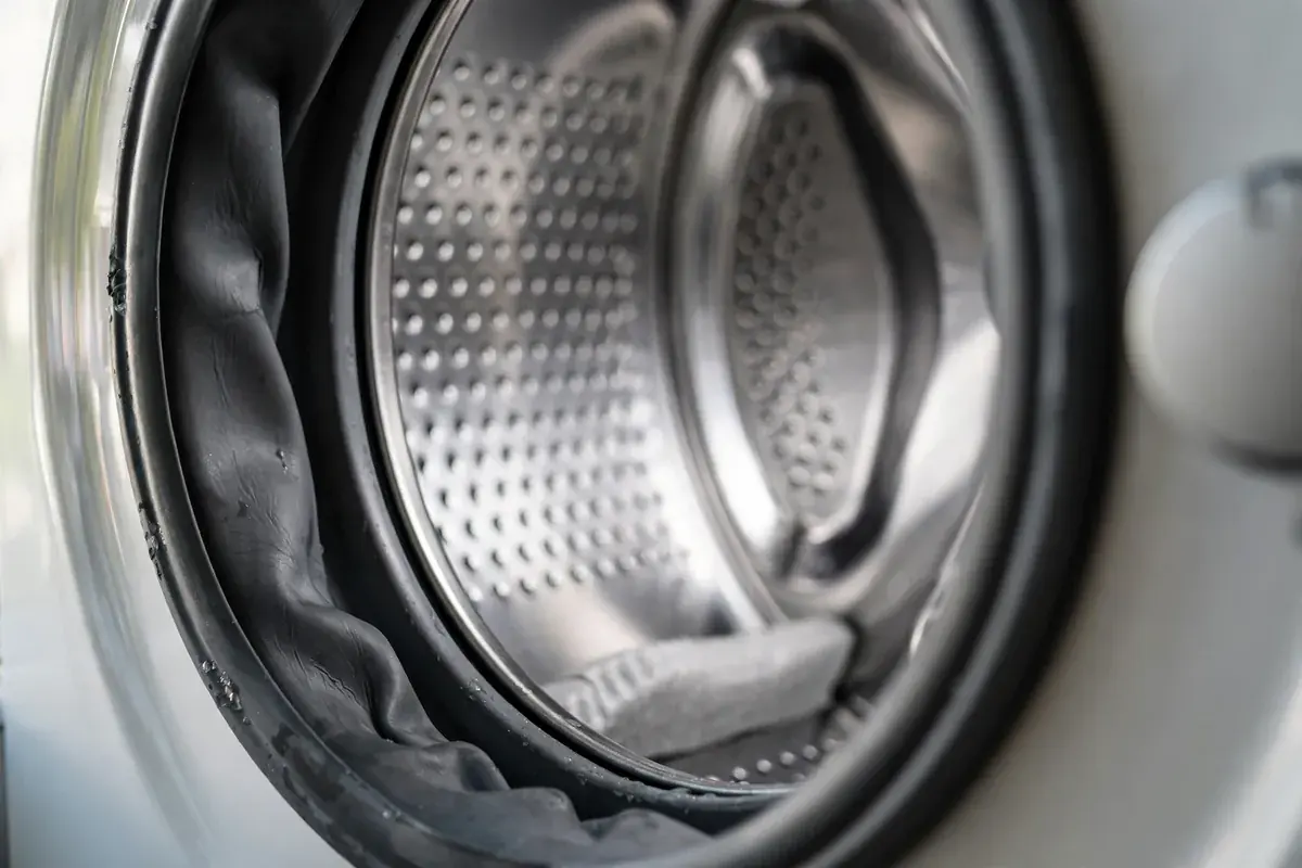 Close view of a washer door seal and clean drum glass in a home laundry setting